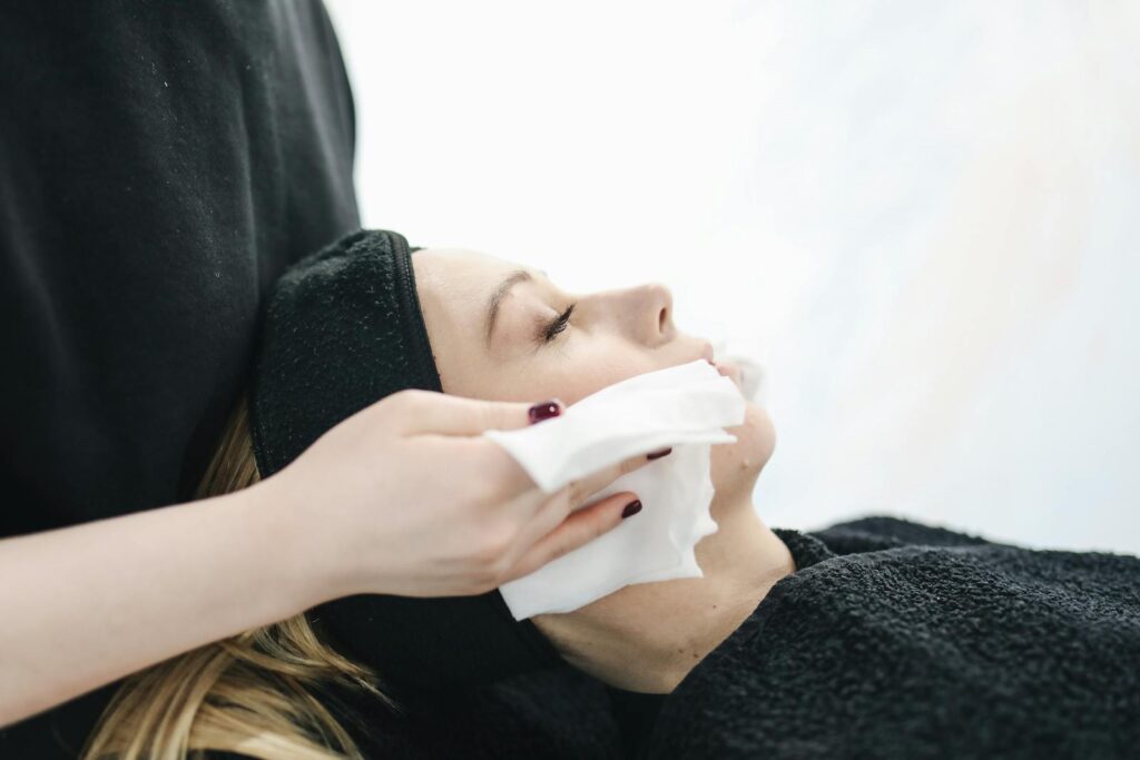 Side view of a woman enjoying a relaxing facial treatment at a spa.