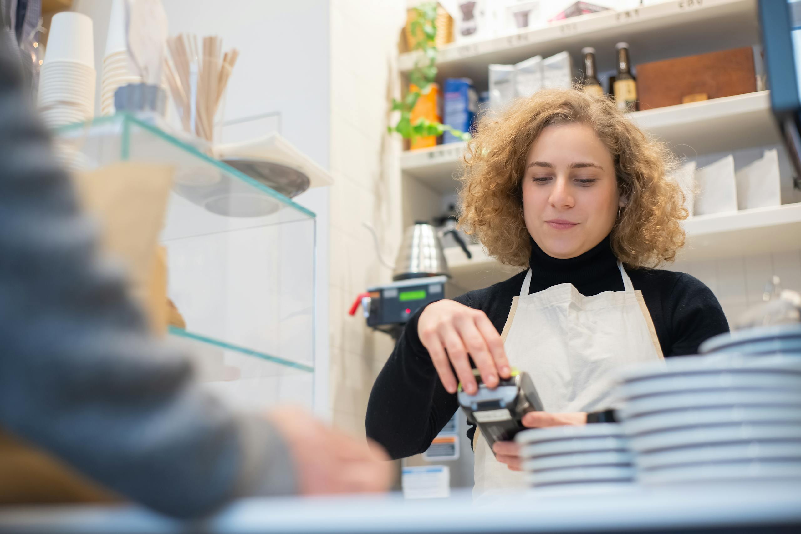 A Low Angle Shot of a Woman Wearing Apron at the Counter